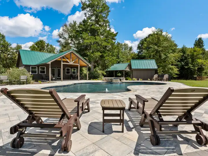 Poolside with lounge chairs and a pavilion